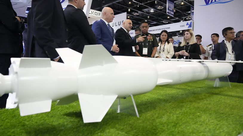 Philippine military chief Gen. Romeo Brawner Jr. center, listens as an exhibitor explains the Wind Demon, a long range air to surface cruise missile, during the Asian Defense and Security Exhibition on Wednesday, Sept. 25, 2024, in Manila, Philippines. (AP Photo/Aaron Favila)