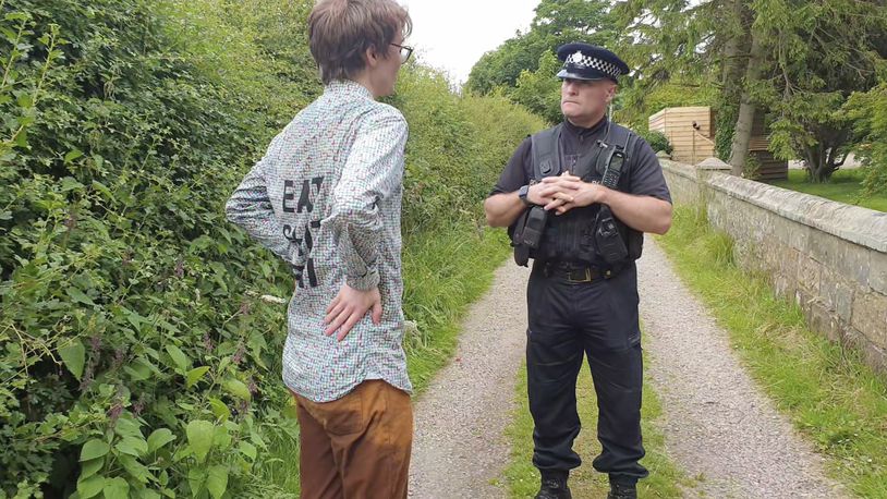 In this photo provided by Youth Demand on Tuesday, June 25, 2024, Oliver, 21, a student from Manchester, one of four protestors, left, speaks to a police officer near Britain's Prime Minister Rishi Sunak’s property, in North Yorkshire, England. Police in northern England say four men have been arrested on suspicion of trespassing on the grounds of Prime Minister Rishi Sunak’s home. North Yorkshire police say the group was detained just after noon and escorted off the property. They were arrested on suspicion of aggravated trespass. (Youth Demand via AP)