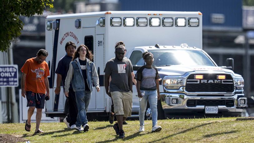 Students and parents walk off campus at Apalachee High School, Wednesday, Sept. 4, 2024, in Winder, Ga. A shooting at the Georgia high school Wednesday caused an unknown number of injuries and a suspect was arrested in a chaotic scene. (AP Photo/Mike Stewart)