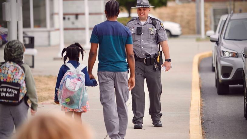 Sgt. Scott Schweinfuth of the Ohio State Highway Patrol greets parents and students Tuesday, September 17, 2024 at Snowhill Elementary in Springfield. MARSHALL GORBY\STAFF