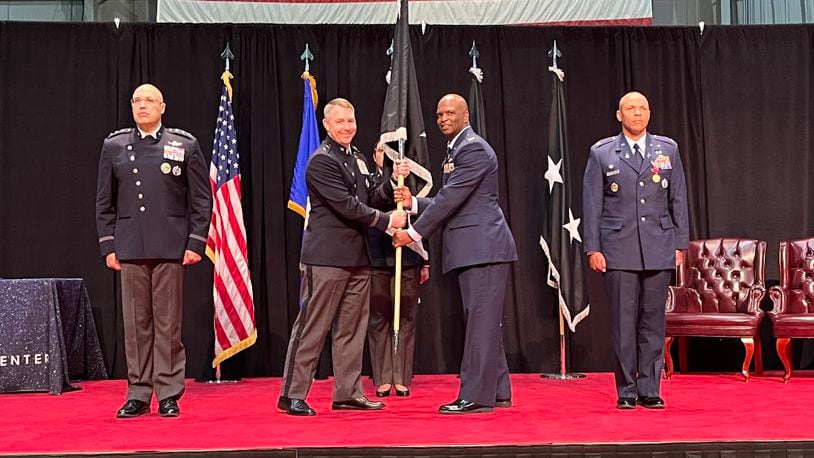 Space Force Col Marcus Starks, to the immediate right of the military guidon or banner, accepted command of the National Space Intelligence Center at Wright-Patterson Air Force Base Friday. Handing off the guidon, on the banner's immediate left, was Maj. Gen. Gregory Gagnon. On the left end of the stage is Lt. Gen. David Miller Jr. On the right side is Col Marqus Randall, the first commander of the National Space Intelligence Center. THOMAS GNAU/STAFF