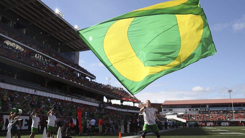 An Oregon cheerleader waves a flag following an Oregon touchdown against Oregon State during the second half of an NCAA football game, Saturday, Sept. 14, 2024, in Corvallis, Ore. (AP Photo/Amanda Loman)