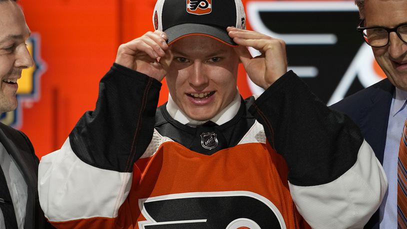 FILE - Matvei Michkov adjust his Philadelphia Flyers hat after being picked by the team during the first round of the NHL hockey draft Wednesday, June 28, 2023, in Nashville, Tenn. (AP Photo/George Walker IV, File)