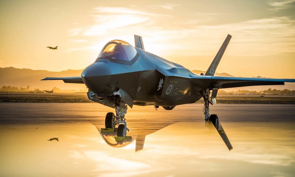 The sun sets behind an Australian F-35A Lighting II at Luke Air Force Base, Ariz., June 27, 2018. The first Australian F-35 arrived at Luke in December 2014. While allies and military pilots appear to love the F-35, it has been the focus of persistent criticism for its cost and difficulty in mainintaining. (U.S. Air Force photo by Staff Sgt. Jensen Stidham) Note: This image was created by placing a reflective surface in front of the the camera lens.