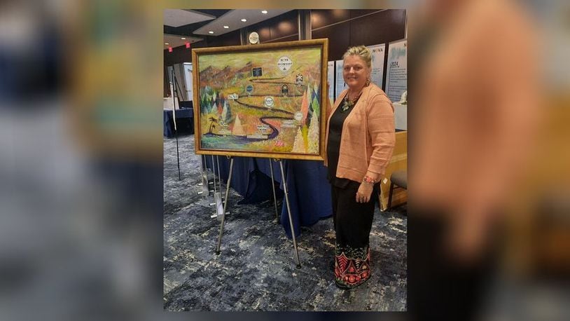 Artist Beckie Neff of Catawba stands with the painting she created for the National Organization of Victim Assistance's 50th anniversary conference in Washington, D.C. She was invited to the event and the painting will remain in its office. CONTRIBUTED