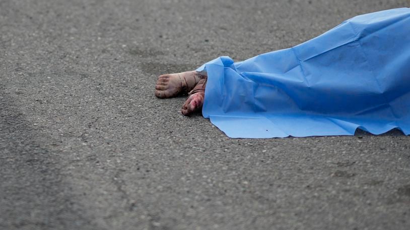 A blue sheet covers a body found lying on the side of a road in Culiacan, Sinaloa state, Mexico, Saturday, Sept. 21, 2024. (AP Photo/Eduardo Verdugo)