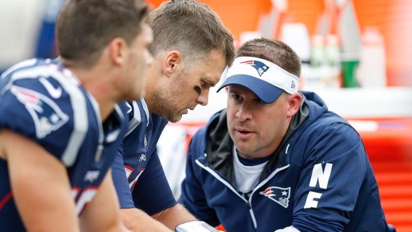 New England Patriots quarterback Tom Brady (12) talks with offensive coordinator Josh McDaniels during the second quarter against the Houston Texans at Gillette Stadium.