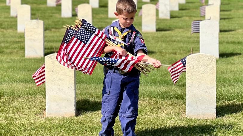 Boy and Girl Scout troops posted American flags at each grave within the Dayton National Cemetery located at the Veterans Medical Center on Saturday. AIMEE HANCOCK/STAFF