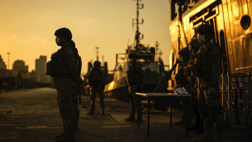 Turkish security officials stand guard next to Turkish military ships preparing to evacuate citizens from Lebanon to Turkey in Beirut port, Wednesday, Oct. 9, 2024. (AP Photo/Emrah Gurel)