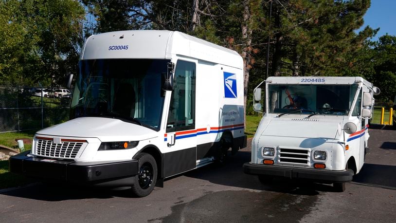 The U.S. Postal Service's next-generation delivery vehicle, left, is displayed as one of the current delivery trucks leaves the Kokomo Sorting and Delivery Center in Kokomo, Ind., Thursday, Aug. 29, 2024. (AP Photo/Michael Conroy)