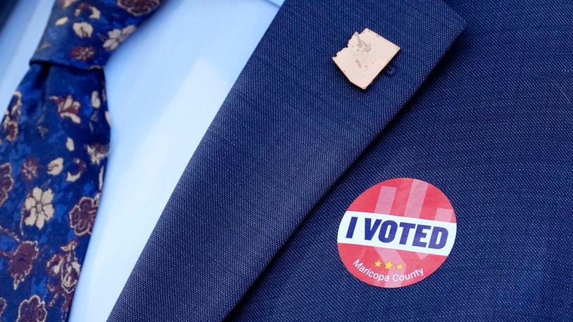 Arizona Secretary of State Adrian Fontes wears an Arizona state pin and an "I Voted" sticker after leaving Surprise City Hall after voting on the first day of early in-person voting for the general election Wednesday, Oct. 9, 2024, in Surprise, Ariz. (AP Photo/Ross D. Franklin)