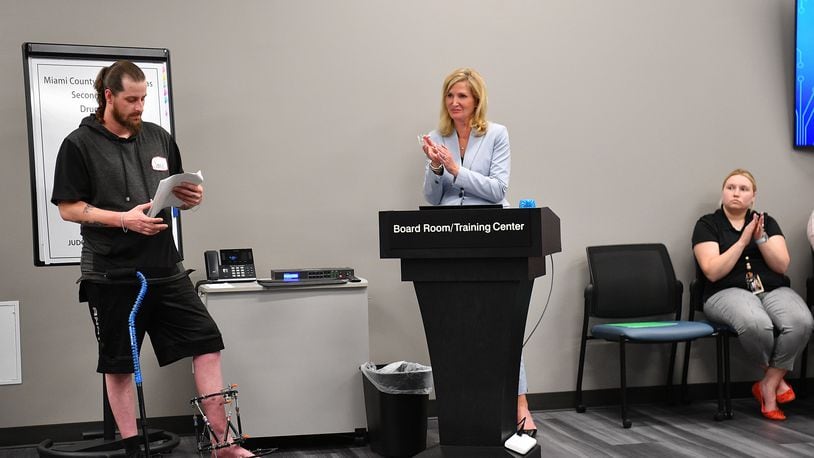 Jamie Arnold of Piqua, left, comments about his efforts to overcome addition during a Miami County Second Chance drug court graduation in May. Judge Jeannine Pratt of Common Pleas Court, who oversees the Second Chance court, is pictured at center. Contributed