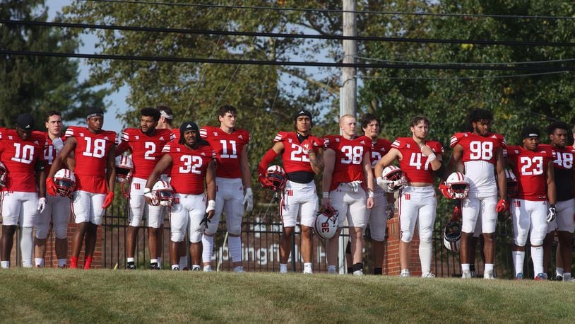 Wittenberg players stand for a moment of silence for late public address announcer Michael Cooper Sr. before a game against Kenyon on Saturday, Sept. 16, 2023, at Edwards-Maurer Field in Springfield. David Jablonski/Staff