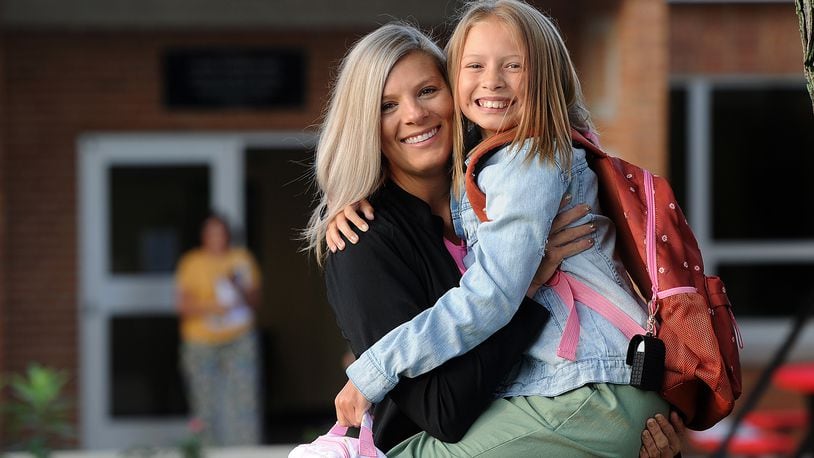 Bekah Stull hugs her daughter Rylee, age 9, goodbye on the first day of school Wednesday, Aug. 16, 2023 at Cline Elementary in Centerville. MARSHALL GORBY\STAFF