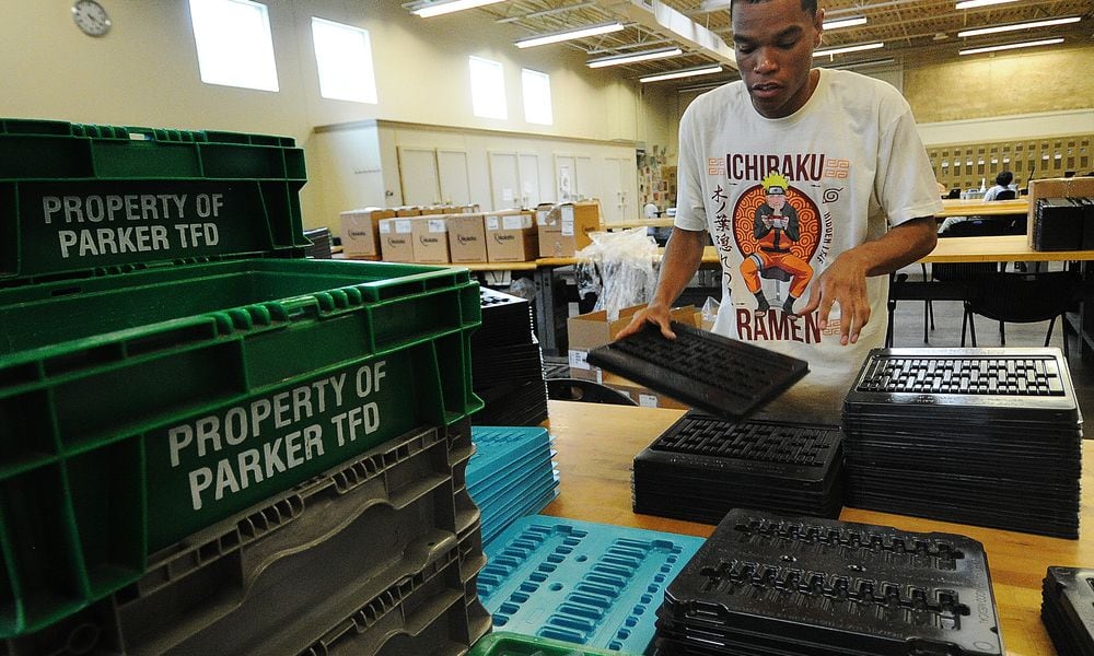 Damien, a worker at Better Living Home Health, stacks plastic trays that will be boxed and shipped away for a company. He is paid through the federal 14c program. MARSHALL GORBY\STAFF