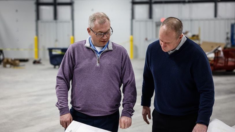 Bill Tolliver, Winsupply vice president for real estate services and in-house counsel, and Rob Ferguson, president of the Winsupply Local Company Group for Winsupply Inc., review plans for Winsupply's new Richard W. Schwartz Center for Innovation in Moraine. JIM NOELKER/STAFF