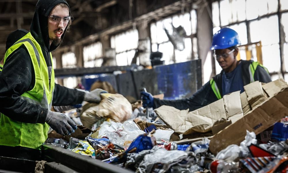 Rumpke recycling sorters Mason Bellmey, left and Tyler Watson pullout trash from cardboard which is recycled. Rumpke recycles 17 to 20 toms of cardboard an hour. JIM NOELKER/STAFF