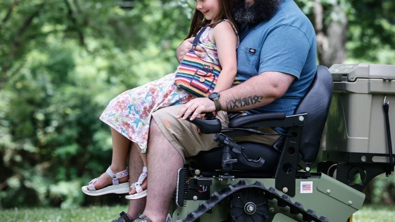 Miamisburg veteran Paul Gibson and his daughter Coralee ride around Crains Run Nature Park Tuesday July 2, after receiving an all-terrain wheelchair from Freedom Alliance a support organization for wounded veterans. JIM NOELKER/STAFF