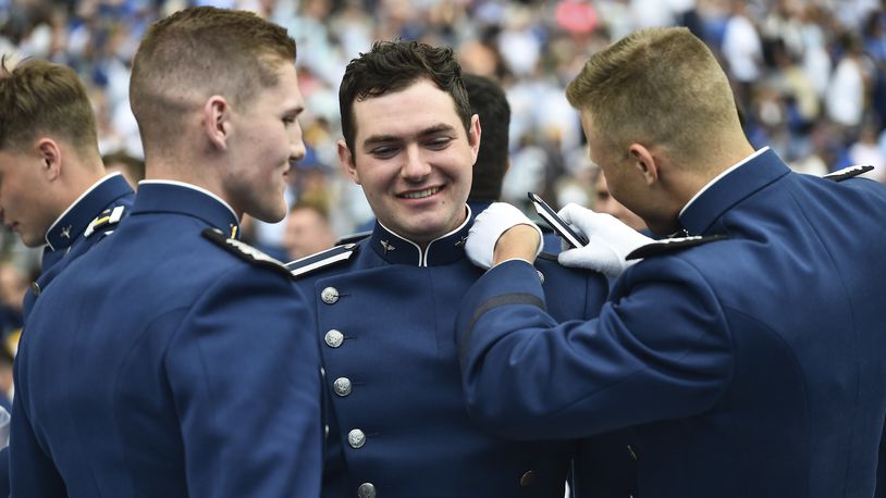 A Cadet gets help with his shoulder boards after graduation ceremonies during the United States Air Force Academy graduation ceremony Thursday, June 1, 2023, at Air force Academy, Colo. (AP Photo/John Leyba)