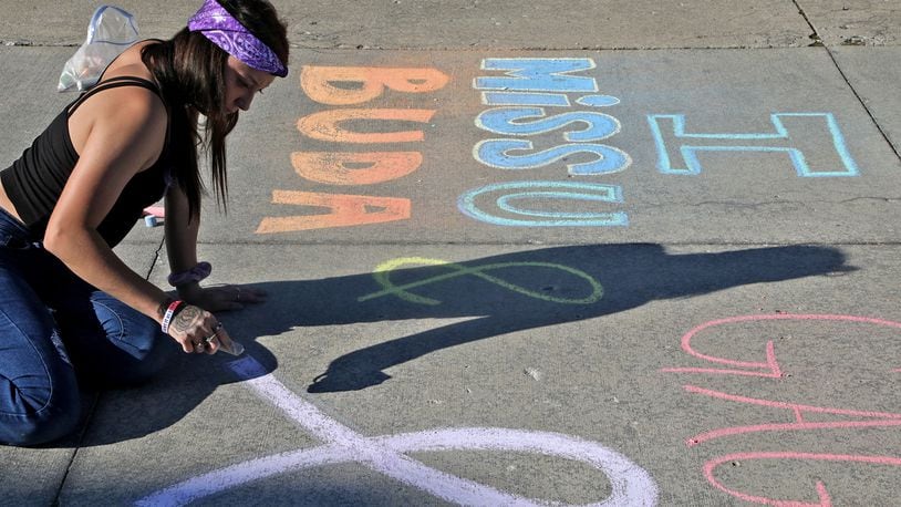 Dejia Hughes draws a picture and message to her friends on the Springfield City Hall Plaza Wednesday, August 31, 2022 during the first ever Chalk the Walk to celebrate the memory of those lost to substance overdose and help prevent future overdoses. Chalk the Walk coincided with International Overdose Awareness Day. The event, presented by the Clark County Substance Abuse Coalition in collaboration with Clark County Partners in Prevention, also featured overdose prevention resources including free Narcan kits. BILL LACKEY/STAFF