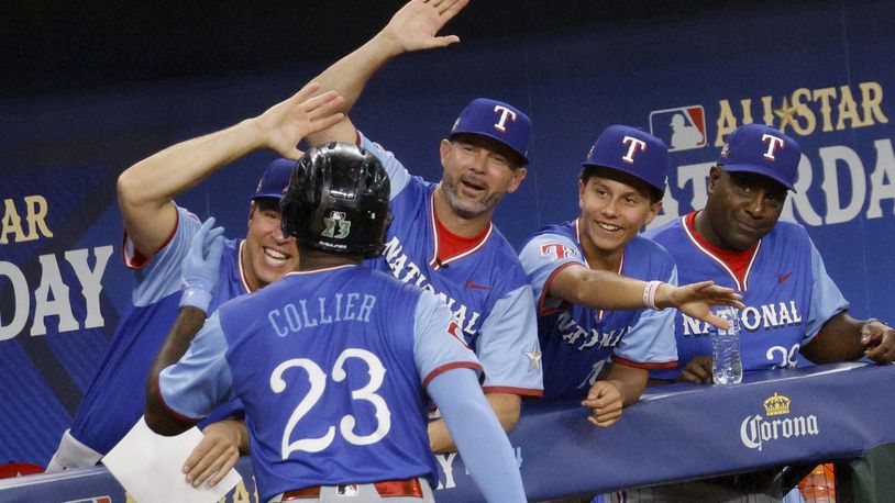 National League's Cam Collier (23) gets high-fives from former Texas Rangers Michael Young, manager for the National League team, third from right, and his teammates after hitting a home run during the third inning of the MLB All-Star Futures baseball game against the American League team Saturday, July 13, 2024, in Arlington, Texas. (Chitose Suzuki/The Dallas Morning News via AP)