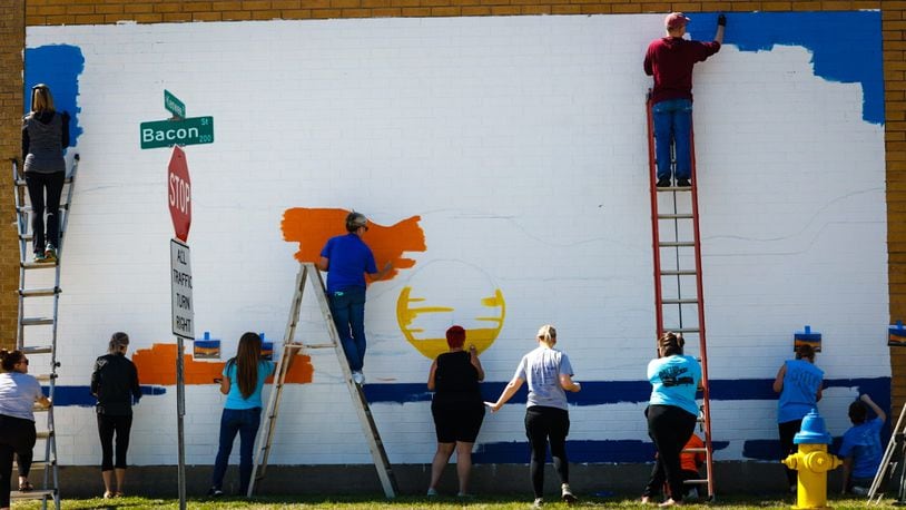 Volunteers from Leadership Dayton Class Project and the ADAMHS Board work on a suicide prevention mural on the Tuffy Brooks Sporting Goods building, located at 101 S. Keowee St. in Dayton. The initiative from the Montgomery County Prevention Coalition to spread messages of hope. The mural will also feature a QR code with a link to mental health resources. JIM NOELKER/STAFF