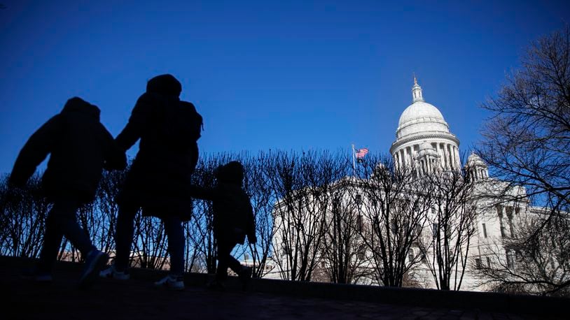 FILE — Pedestrians walk past the Rhode Island Statehouse, March 1, 2020, in Providence, R.I. (AP Photo/David Goldman, File)