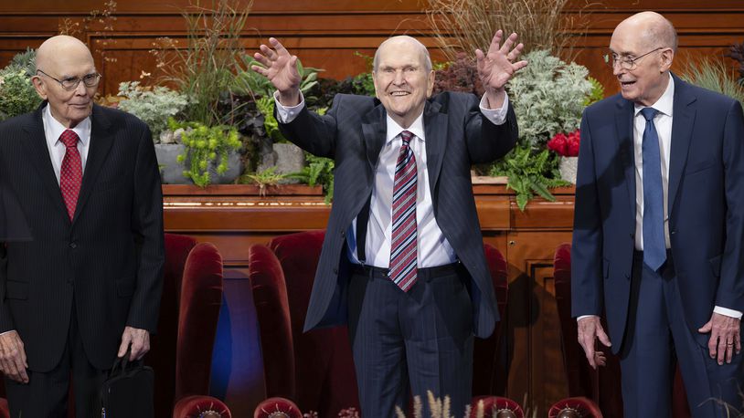 Church of Jesus Christ of Latter-day Saints President Russell M. Nelson, center, waves to the crowd as he joins his counselors, President Dallin H. Oaks, left, first counselor in the First Presidency, and President Henry B. Eyring, second counselor in the First Presidency, at the afternoon session of the 194th Semiannual General Conference of The Church of Jesus Christ of Latter-day Saints in the Conference Center in Salt Lake City, Saturday, Oct. 5, 2024. (Scott G Winterton/The Deseret News via AP)