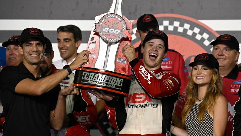 Harrison Burton, center right, celebrates with the championship trophy after winning a NASCAR Cup Series auto race at Daytona International Speedway, Saturday, Aug. 24, 2024, in Daytona Beach, Fla. (AP Photo/Phelan M. Ebenhack)