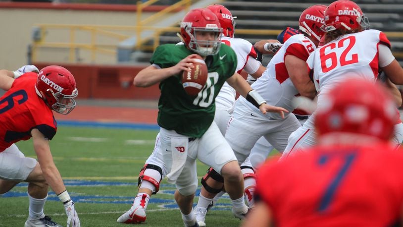 Dayton quarterback Jack Cook scrambles during Sunday’s spring game at Welcome Stadium. Mike Hartsock/STAFF