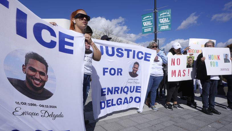 People display signs with with a likeness of Massachusetts State Police recruit Enrique Delgado-Garcia, who died following a State Police Academy training exercise, at a protest outside the State Police Academy graduation ceremony, Wednesday, Oct. 9, 2024, at the DCU Center, in Worcester, Mass. (AP Photo/Steven Senne)