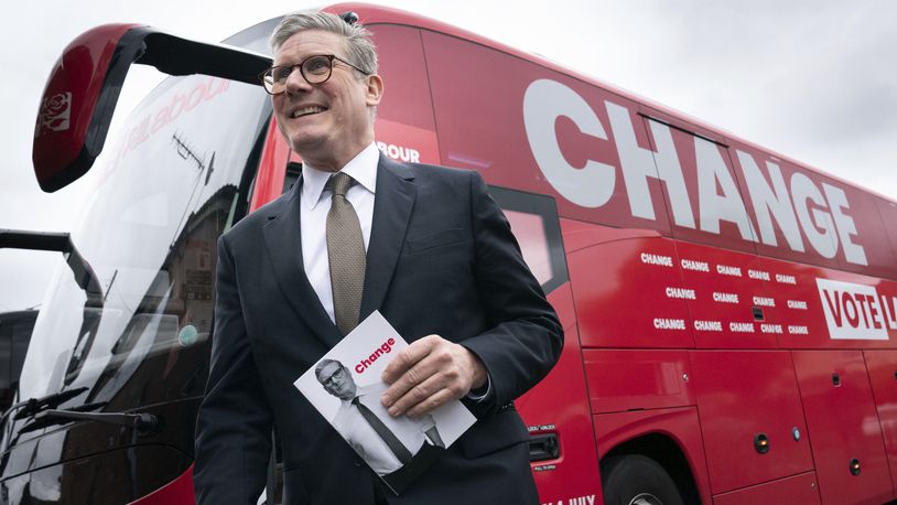 Labour Party leader Sir Keir Starmer arrives on board his election battle bus at a campaign event in Halesowen county of West Midlands, England, Thursday, June 13, 2024, after unveiling Labour's manifesto in Manchester for the forthcoming General Election on July 4. (Stefan Rousseau/PA via AP)