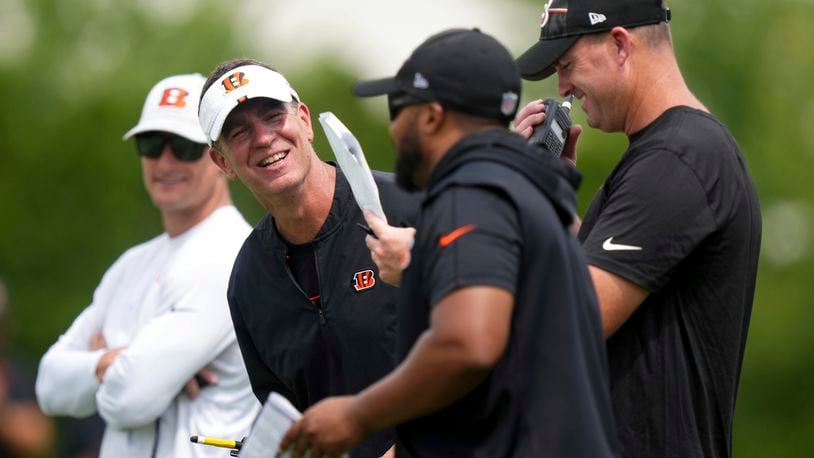 Cincinnati Bengals defensive coordinator Lou Anarumo, second from left, laughs with secondary/cornerbacks coach Charles Burks, second from right, and head coach Zac Taylor, right, during the team's NFL football training camp practice, Friday, July 28, 2023, in Cincinnati. (Kareem Elgazzar/The Cincinnati Enquirer via AP)