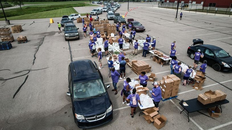 Foodbank and CareSource hosted a mini food distribution at the Montgomery County Fairground Thursday June 20, 2024. Over 600 families registered and the Dayton Flyers basketball team helped with the distribution. JIM NOELKER/STAFF