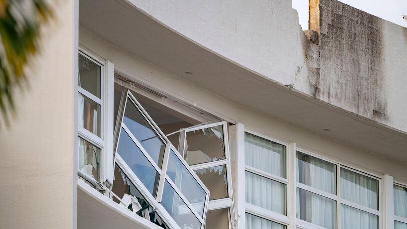 A broken window hands precariously at the Double Tree by Hilton Hotel in Cairns, Australia, after a helicopter crashed into its roof early Monday, Aug. 12, 2024. (Brian Cassey/AAP Image via AP)