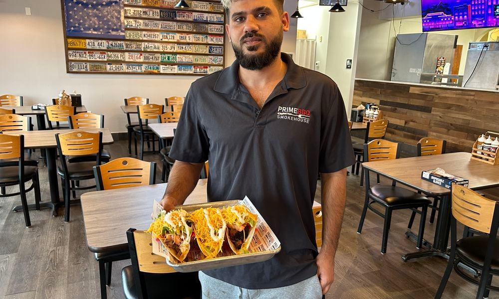 Nawaf Nayyef from Prime BBQ Smokehouse in Monroe delivers a plate of tacos to a customer. The restaurant has added to its menu, including three tacos on Taco Tuesdays for $8.99. RICK McCRABB/STAFF