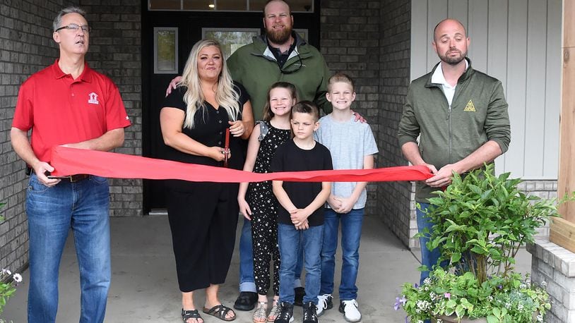 Operation FINALLY HOME executive director Rusty Carroll (left) along with Josh Dungan of JM Dungan Custom Homes (far right) welcome the Zurn family (L-R Brittany, Aaron, daughter Tatum, Sons Porter and Keegan) Through community donations, the Zurn family also received new furniture for their home. CONTRIBUTED