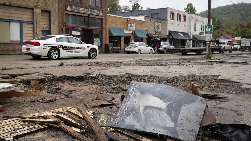 A Madison County sheriff's vehicle passes damaged buildings along Bridge Street in the aftermath of Hurricane Helene Tuesday, Oct. 1, 2024, in Hot Springs, N.C. (AP Photo/Jeff Roberson)