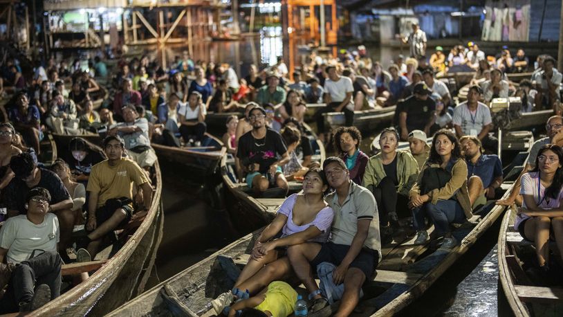 Spectators watch a film from boats during the Muyuna Floating Film Festival, showcasing films from countries with tropical forests, in the Belen neighborhood of Iquitos, Peru, on Sunday, May 26, 2024. (AP Photo/Rodrigo Abd)
