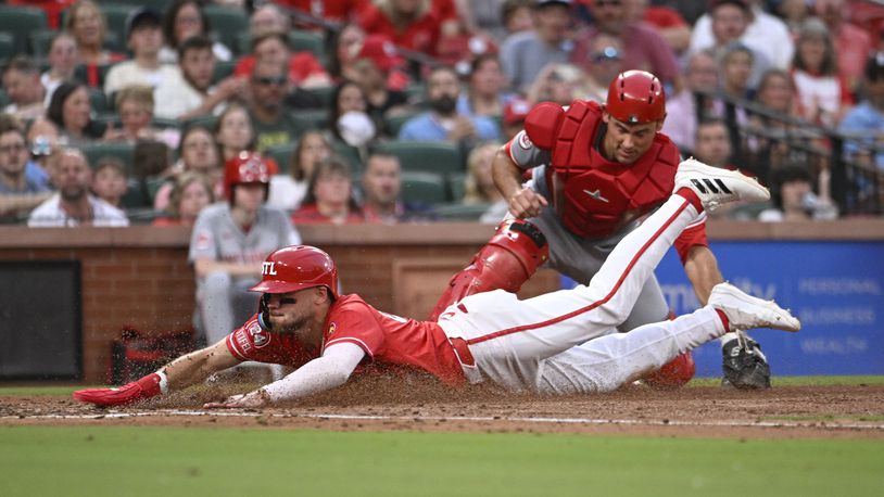 St. Louis Cardinals' Michael Siani, left, slides safely for a run at home plate ahead of a tag by Cincinnati Reds catcher Luke Maile, right, in the third inning of a baseball game, Friday, June 28, 2024, in St. Louis. (AP Photo/Joe Puetz)
