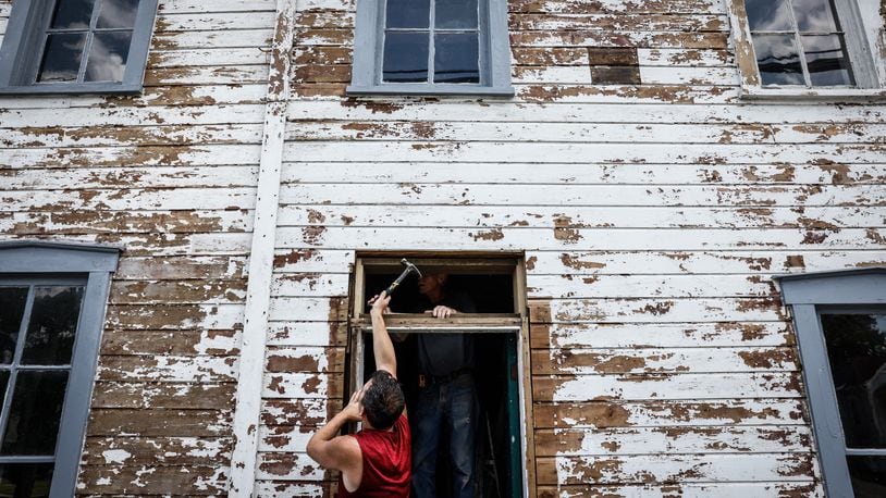 Carpenter Toby Arnold installs a transom window on the buggy whip building in downtown Tipp City Friday July 7, 2023. Jim Noelker/Staff