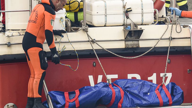 Italian firefighter divers bring ashore in a plastic bag the body of one of the victims of a shipwreck, in Porticello, Sicily, southern Italy, Thursday, Aug. 22, 2024. Divers searching the wreck of the superyacht Bayesian that sank off Sicily on Monday recovered a fifth body on Thursday and continued to search for one more as investigators sought to learn why the vessel sank so quickly. (AP Photo/Salvatore Cavalli)