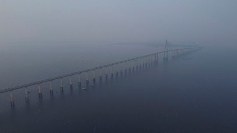 Smoke from wildfires fills the air along the Jornalista Phelippe Daou bridge over the Negro River in Manaus, Amazonas state, Brazil, Tuesday, Aug. 27, 2024. (AP Photo/Edmar Barros)