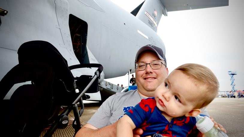 Ben Kerchner and his 10-month-old son Daniel hang out under the wing of a C-17 aircraft Sunday, June 23, 2024 at the Dayton Air Show. MARSHALL GORBY \STAFF
