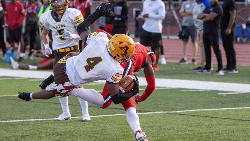 Alter's Rod Owens dives into the end zone over Trotwood-Madison's Darius Dennis early in the second quarter Thursday night in Trotwood. Jeff Gilbert/CONTRIBUTED