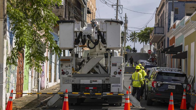 Electric workers carry out repairs in the community of Puerta de Tierra after the passage of Tropical Storm Ernesto in San Juan, Puerto Rico, Thursday, Aug. 15, 2024. (AP Photo/Alejandro Granadillo)