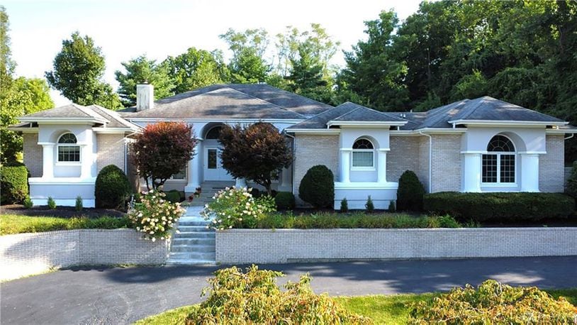 The brick and Hardiplank sided ranch style home has a circular driveway that leads to a three car side entry attached garage.