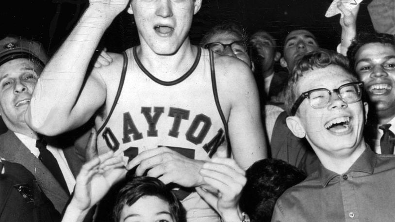 3-24-1962 NEW YORK: Bill Chmielewski, who led Dayton to a 73-67 victory over St. John’s in the finals of the National Invitation Basketball Tournament, is mobbed by delirious fans at the end of the game. On his head is the trophy he received as the most valuable player. UPI TELEPHOTO