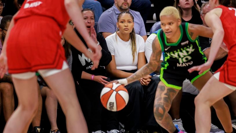 Maya Moore Irons, center, watches the WNBA basketball game between the Minnesota Lynx and the Indiana Fever on Saturday, Aug. 24, 2024, in Minneapolis. (Kerem Yücel/Minnesota Public Radio via AP)