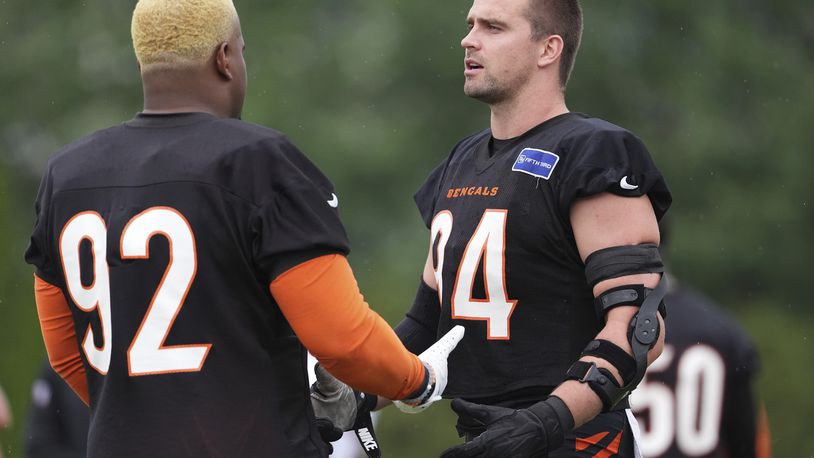 Cincinnati Bengals defensive tackle B.J. Hill, left, and defensive end Sam Hubbard, right, slap hands during the team's NFL football training camp Sunday, July 28, 2024, in Cincinnati. (AP Photo/Kareem Elgazzar)